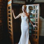 Bride in wedding dress in vintage telephone booth