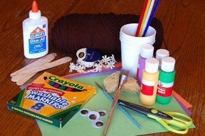 Pile of craft supplies including glue, markers, cups, paint, and scissors=