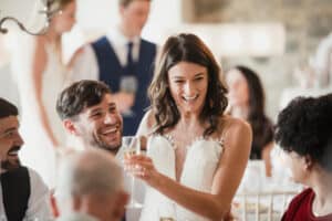 A groom looks at his spouse, as she gives a toast during their Delaware Wedding.