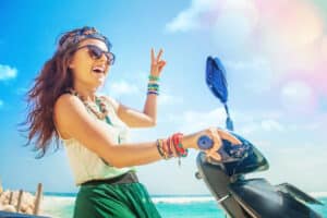 A young woman smiles on her scooter in Rehoboth Beach-- with the help of Boardwalk Hotel's guide.