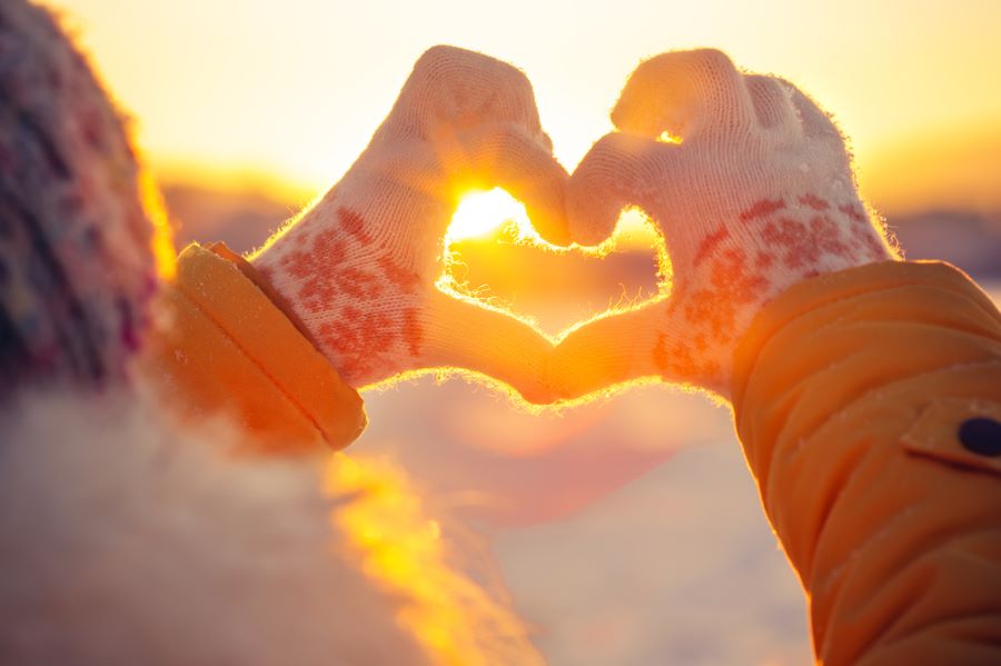 A gloved hand forms a heart at sunset during a holiday in Rehoboth Beach, DE.