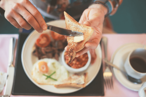 A close up of a slice of toast being buttered, during breakfast in Rehoboth Beach.